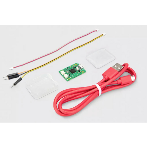 Ein USB-Daten- und Ladekabel, eine kleine grüne Platine und zwei Sätze dünner Kabel sind auf einer hellen Oberfläche angeordnet.
